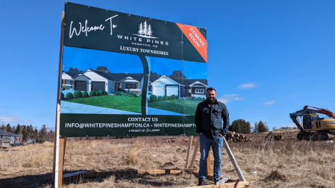 Man in front of development sign 