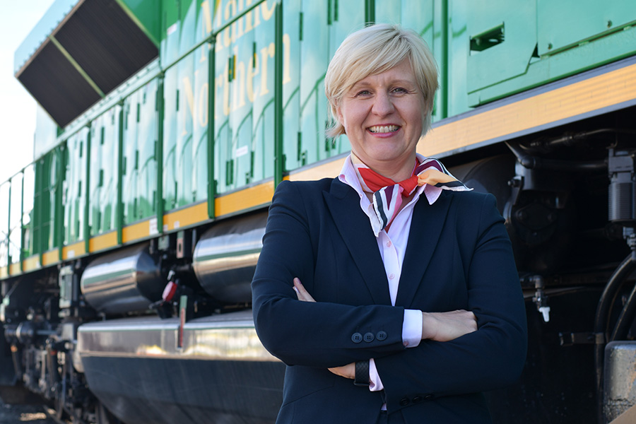 Woman in front of train smiling