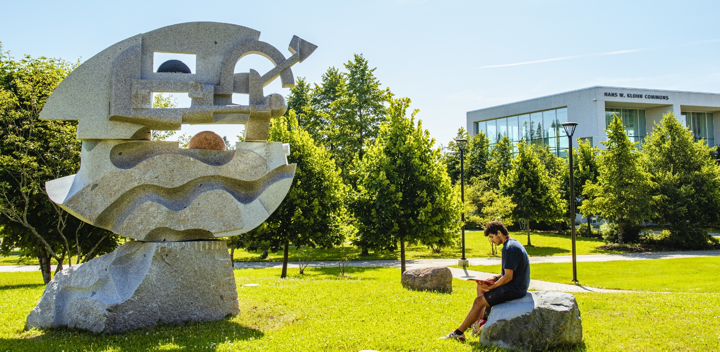 person sitting in front of an art sculpture