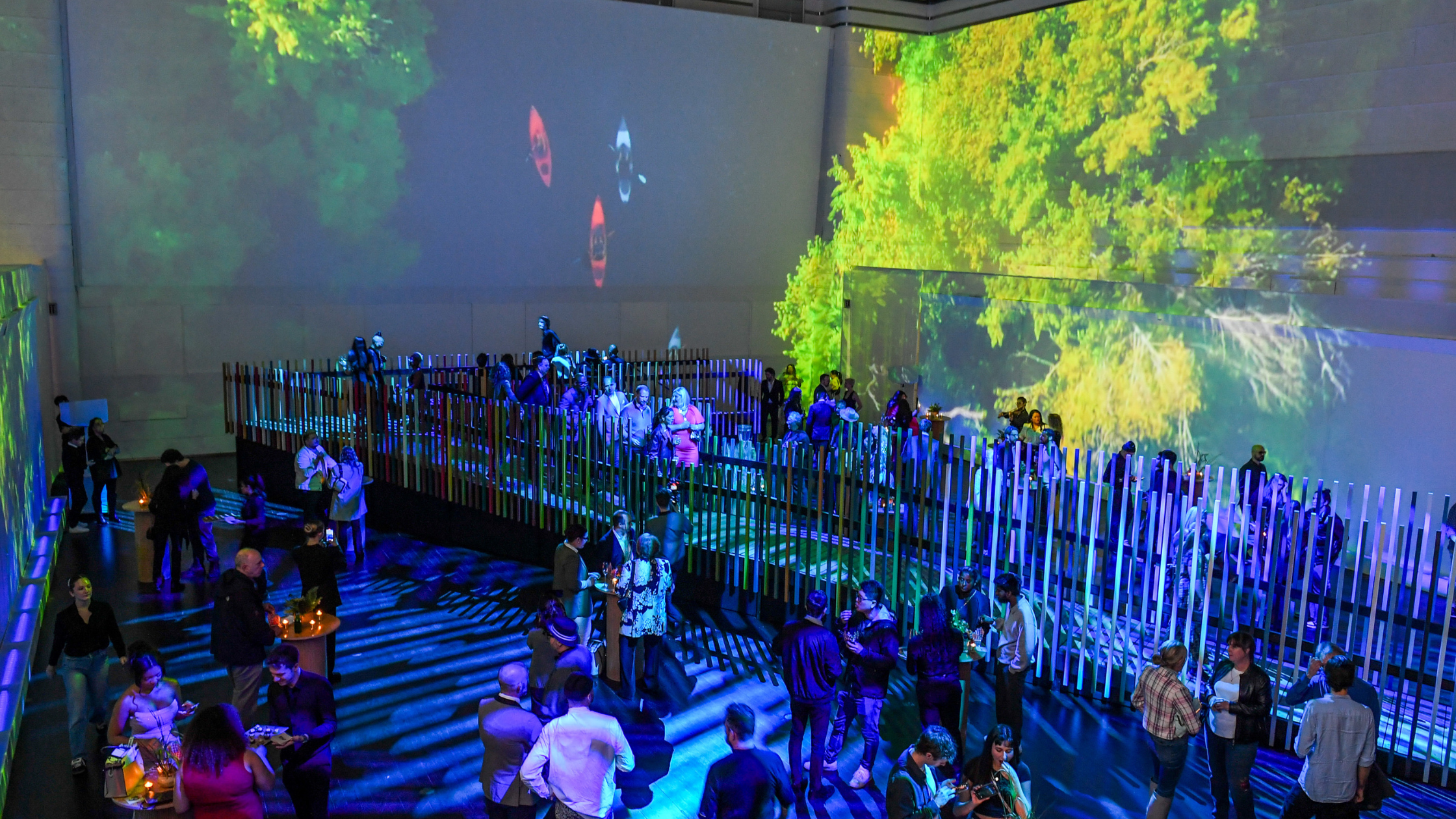 a dark room with a structure surrounded by large screens
