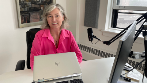 Woman in front of computer smiling