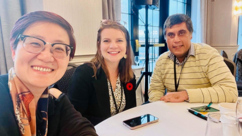 three people at table smiling