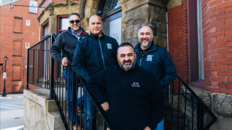 Four men in stairs smiling