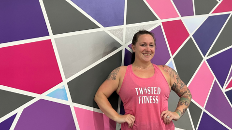 woman standing against colourful wall in fitness studio