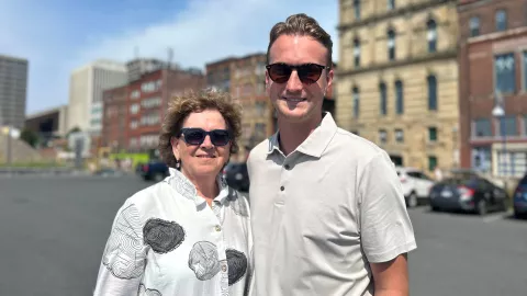 two people standing in front of historic buildings 